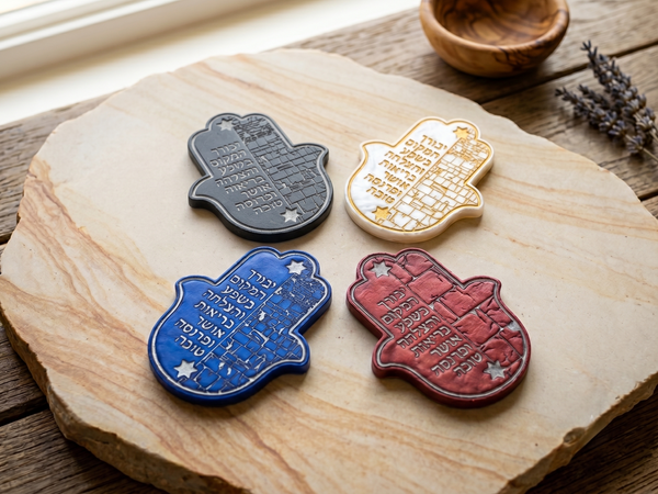 Four handcrafted Jewish home blessing ornaments featuring Hamsas, with traditional Kabbalah design elements.