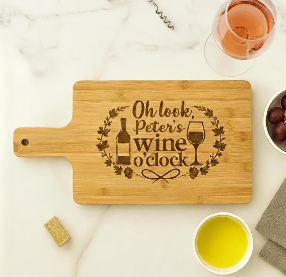 Acacia wood cutting board with "Oh Look It's Wine O'Clock" quote, perfect for wine lovers and serving wine at gatherings.