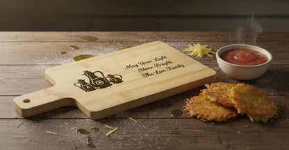 Personalized Hanukkah cutting board by The Present Spot, engraved oil lamps and family name on acacia wood, perfect Jewish gift.